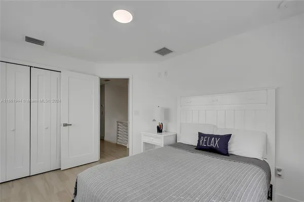 a bedroom with a white bed and white walls