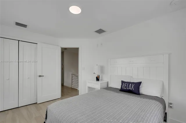 a bedroom with a white bed and white walls