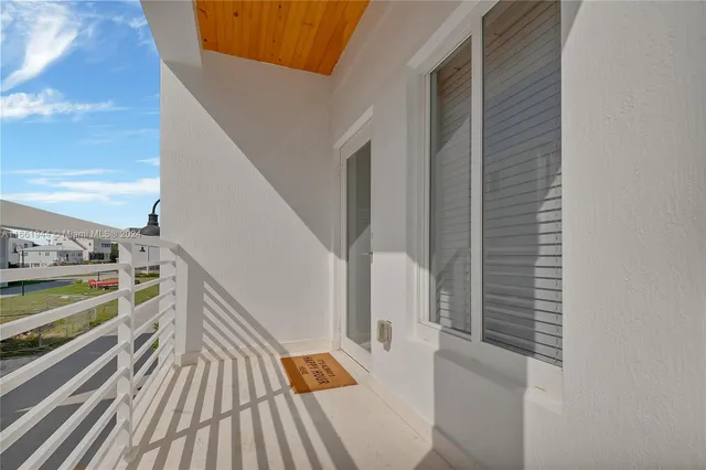 front view of a brick house with potted plants