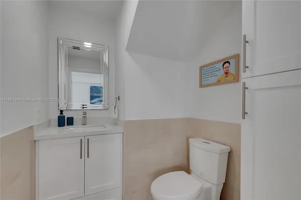 a bathroom with a toilet sink vanity and mirror