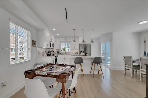 a kitchen with kitchen island a stove a table and chairs in it