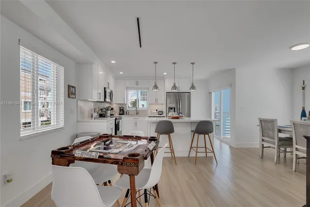 a kitchen with kitchen island a stove a table and chairs in it