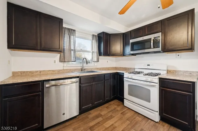 a kitchen with stainless steel appliances granite countertop a refrigerator a oven a sink with a dining table and chairs