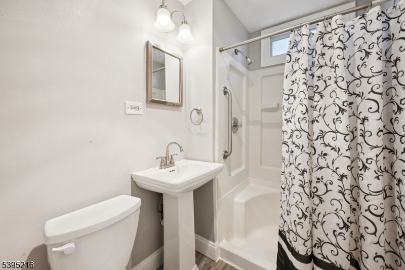 610 Lee Avenue Beverly, NJ 08010 - Photo 16 of 21 a bathroom with a sink a toilet and shower curtain