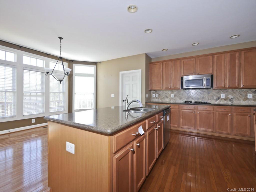 713 Reverdy Court Fort Mill, SC 29708 - Photo 8 of 19 a kitchen with stainless steel appliances granite countertop a sink cabinets and wooden floor