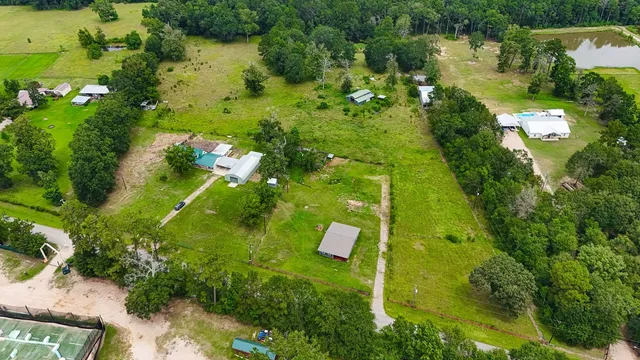 an aerial view of residential houses with outdoor space and trees all around