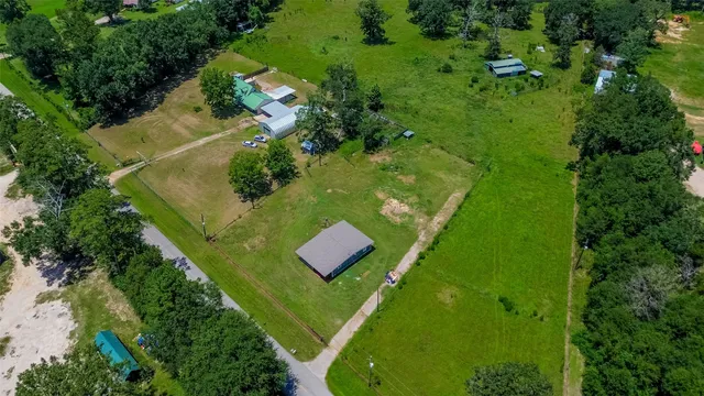 an aerial view of residential houses with outdoor space and trees