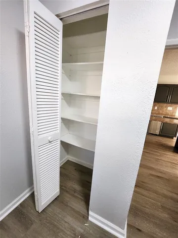 a view of a hallway with wooden floor and entryway
