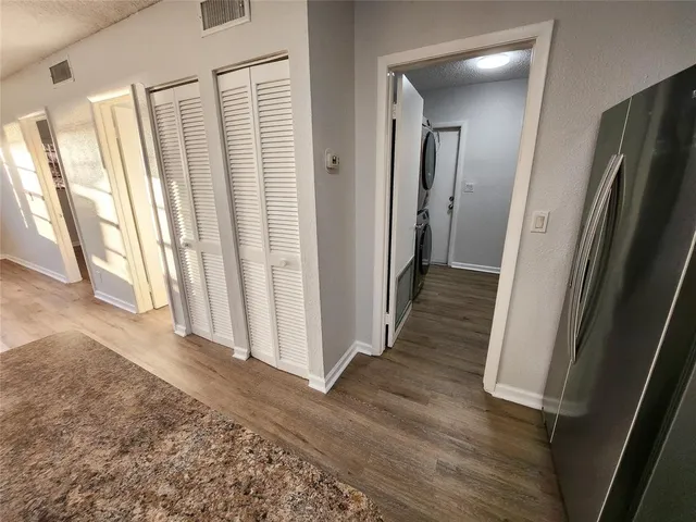 a view of a hallway with wooden floor and door