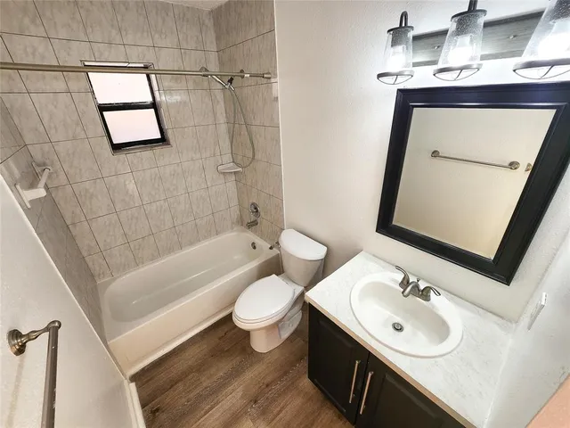 a bathroom with a sink a toilet a mirror a bathtub and shower