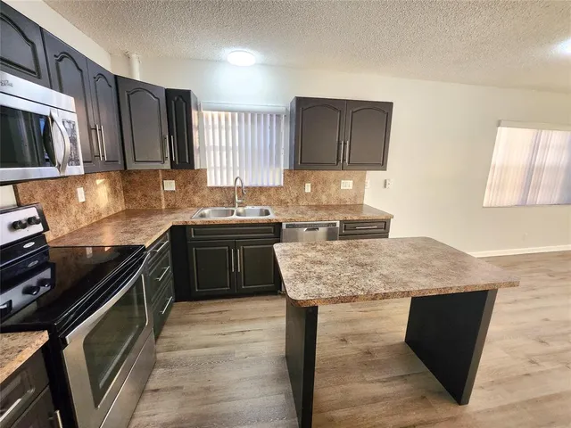 a kitchen with a sink stove top oven and microwave
