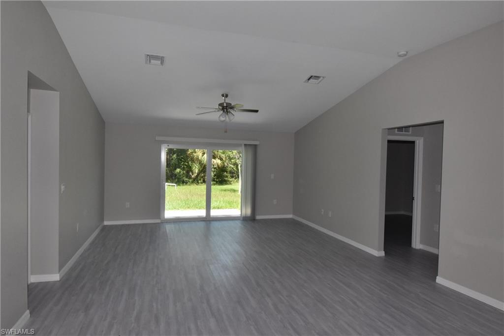 2121 Firebrand Road North Port, FL 34288 - Photo 7 of 22 Empty room featuring vaulted ceiling, dark wood-style flooring, and a ceiling fan