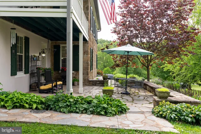 a living room with furniture a fireplace a flat screen tv and windows