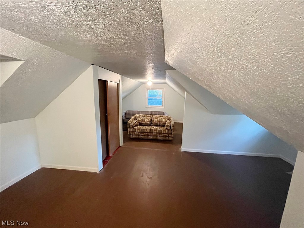 3859 Randolph Road Mogadore, OH 44260 - Photo 14 of 17 Bedroom with dark hardwood flooring, vaulted ceiling, and a textured ceiling