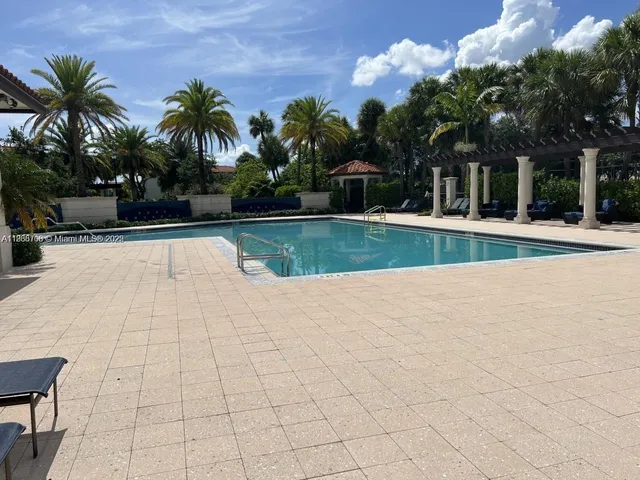 a view of swimming pool with table and chairs under an umbrella