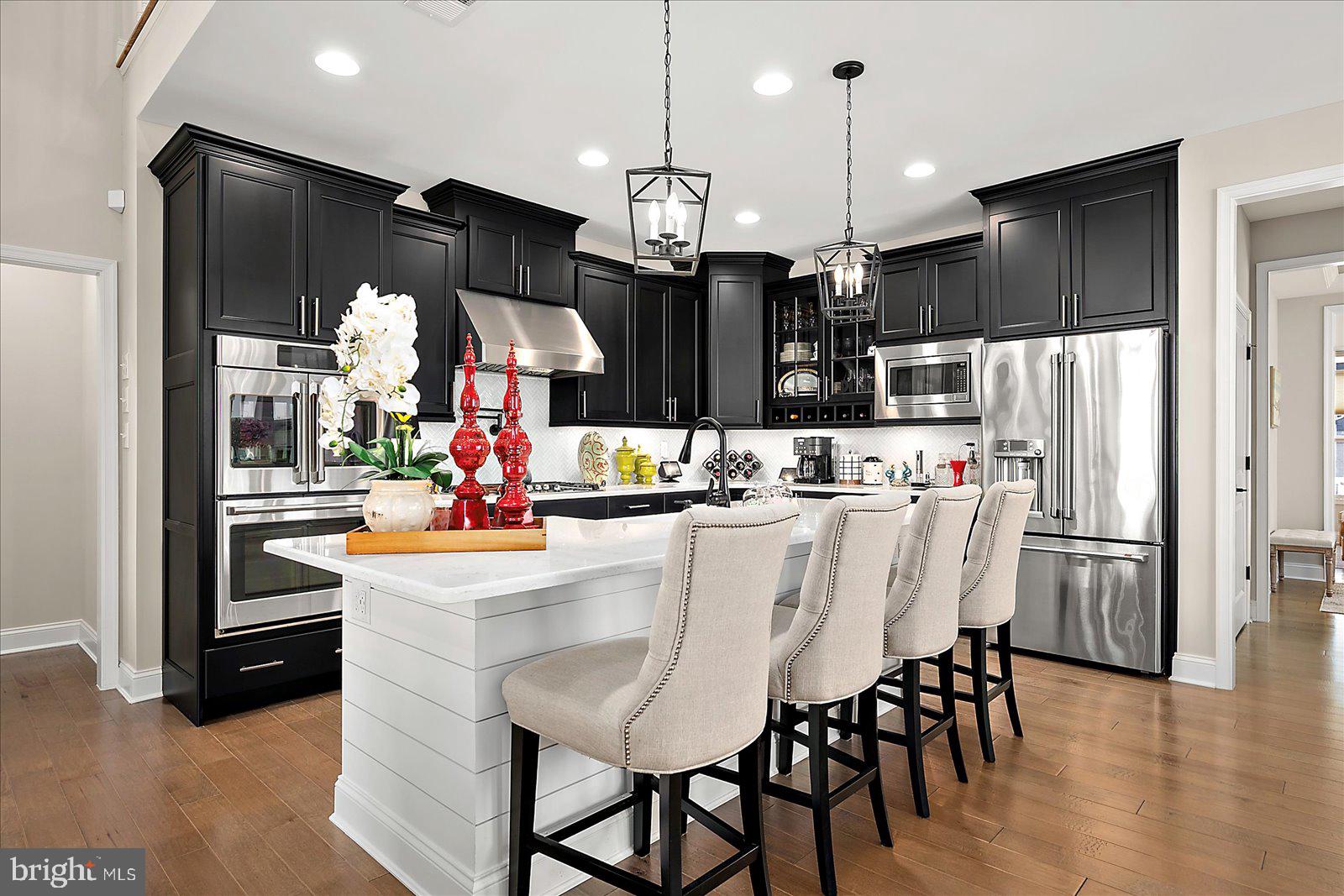19218 American Holly Road Rehoboth Beach, DE 19971 - Photo 10 of 107 a kitchen with stainless steel appliances kitchen island granite countertop a refrigerator a stove top oven a sink and a island