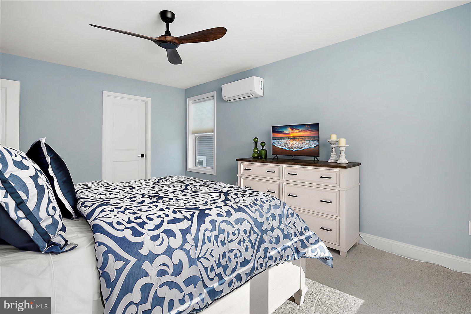 19218 American Holly Road Rehoboth Beach, DE 19971 - Photo 59 of 107 a bedroom with a bed and a chandelier