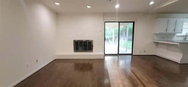 an empty room with wooden floor and a fireplace