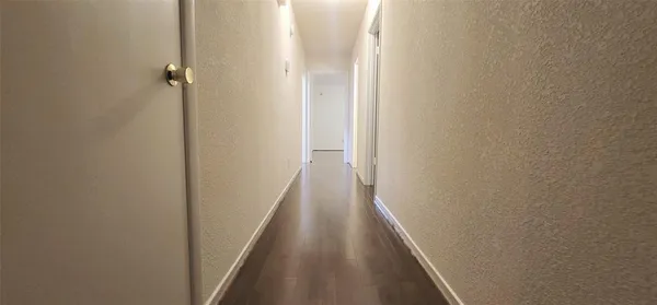 a view of a hallway with wooden floor
