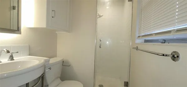 a bathroom with a sink a toilet and shower