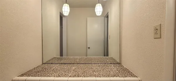 a view of a hallway with wooden floor and white walls