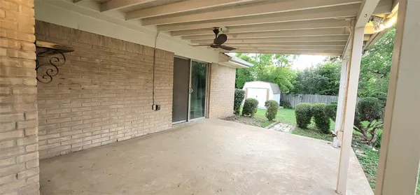 a view of a chair and table in backyard of the house
