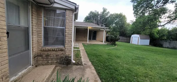 a view of a house with a yard and large trees