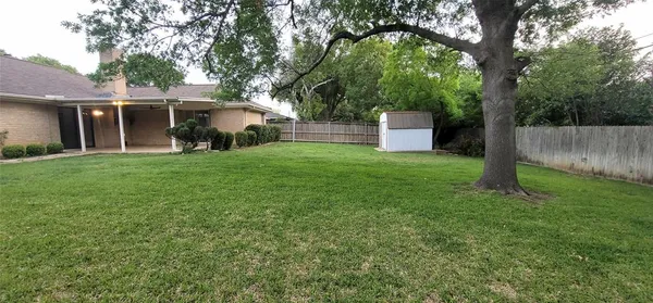 a view of a backyard with a cabin and wooden fence