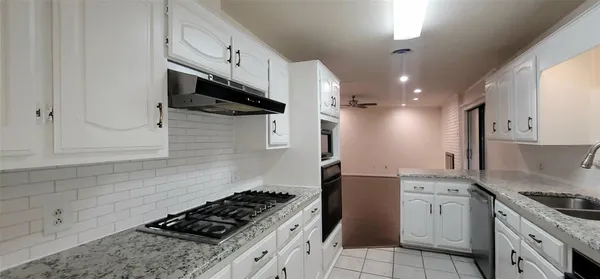 a kitchen with granite countertop a stove and a sink