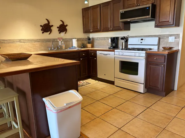 a kitchen with a sink a stove and cabinets