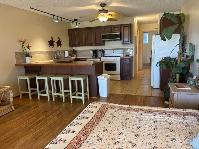 a kitchen with kitchen island granite countertop a sink cabinets and stainless steel appliances