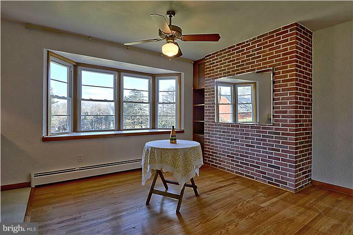 805 Crest Hill Road Severn, MD 21061 - Photo 6 of 20 Dining area with brick wall and hardwood floors.