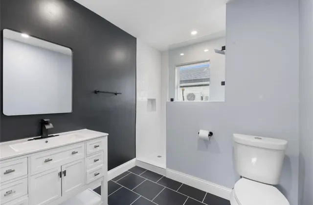 a bathroom with a toilet sink and mirror