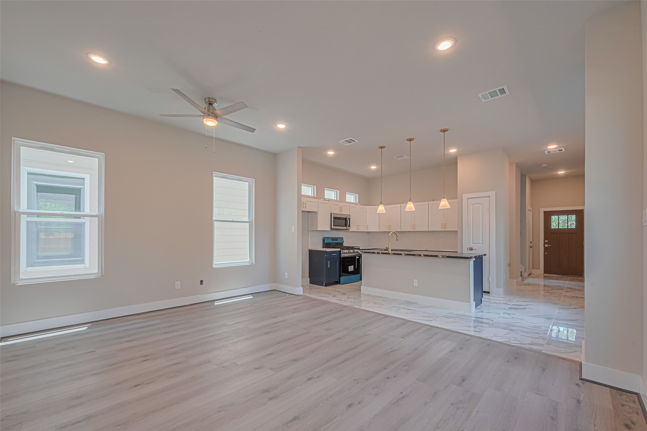 2414 Sam Wilson Street Houston, TX 77020 - Photo 5 of 29 an empty room with wooden floor and kitchen