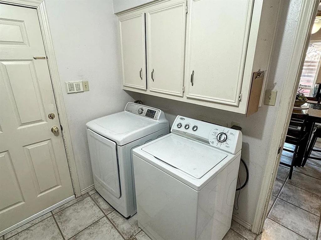 9911 Silver Creek Road Dallas, TX 75243 - Photo 25 of 28 Laundry area featuring overhead cabinetry, a paneled door, and tile flooring