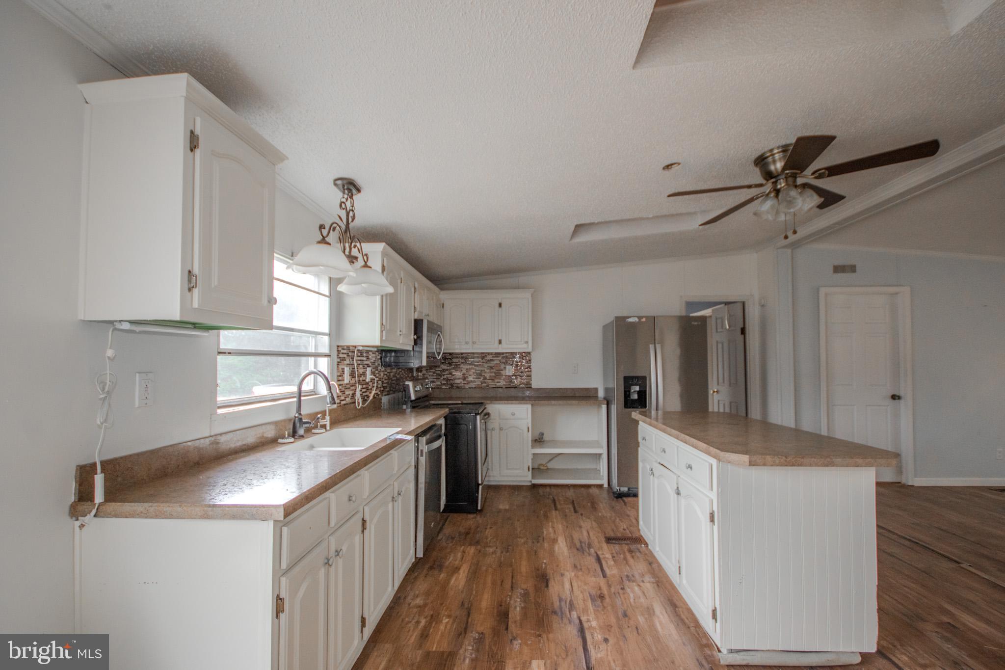 3887 Texas Road Bivalve, MD 21814 - Photo 11 of 34 a kitchen with stainless steel appliances granite countertop a sink stove and refrigerator