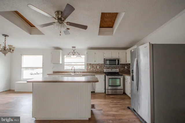 a kitchen with kitchen island a sink stainless steel appliances and window