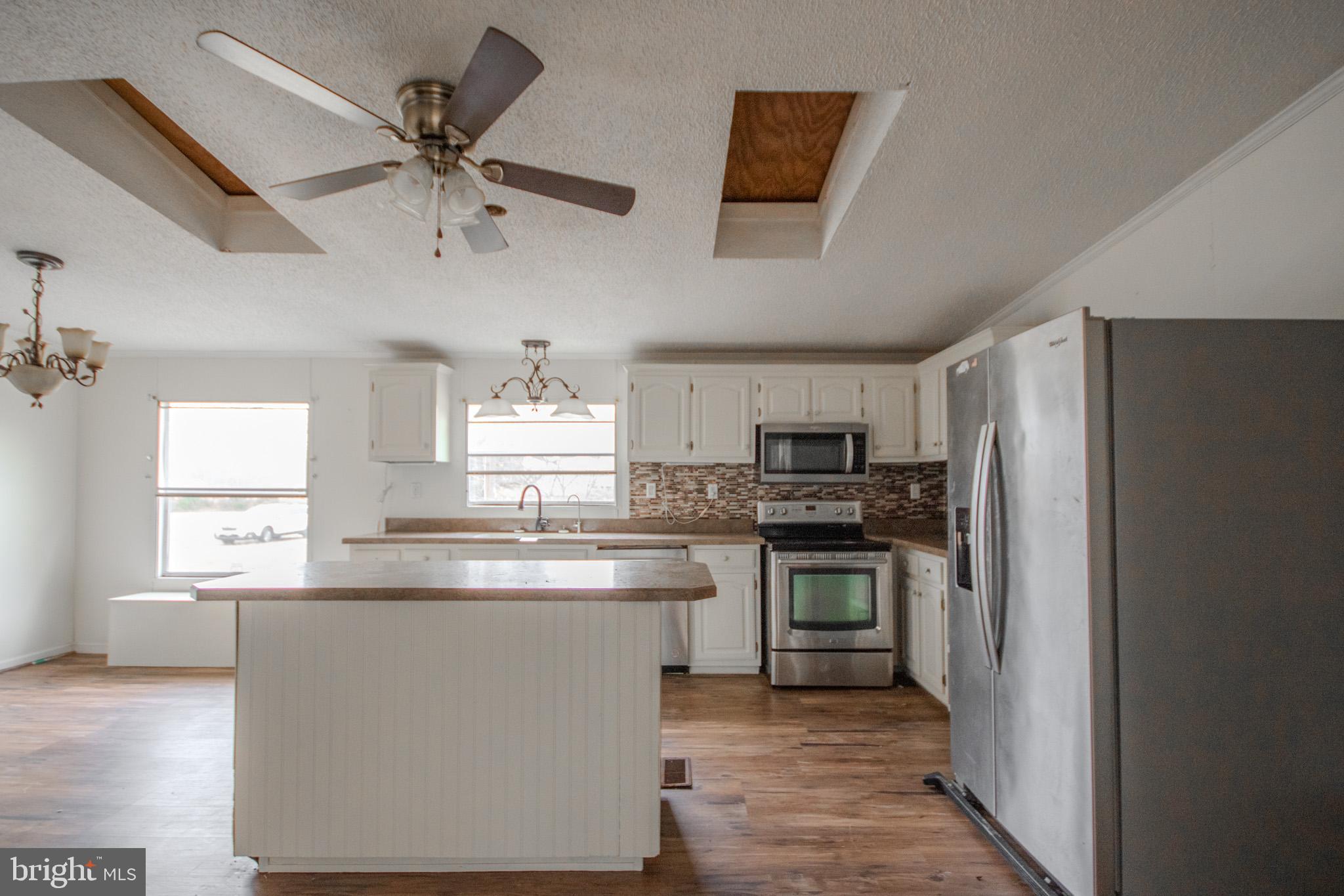 3887 Texas Road Bivalve, MD 21814 - Photo 12 of 34 a kitchen with kitchen island a sink stainless steel appliances and window