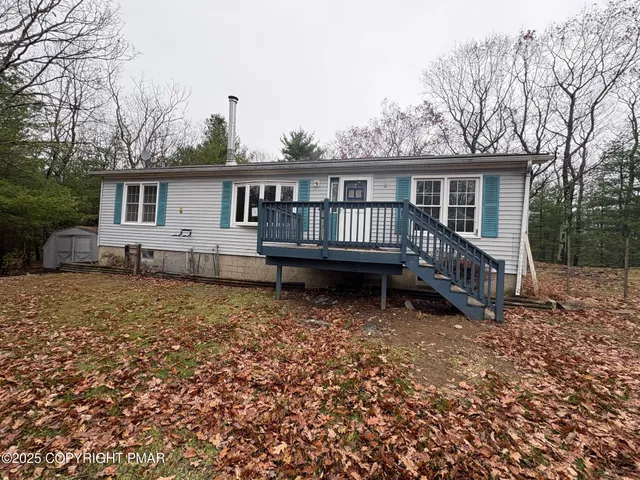 a view of a house with a yard and wooden fence