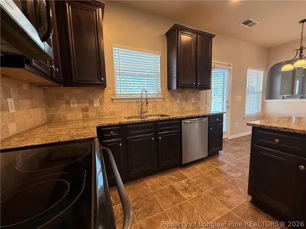 a kitchen with a sink stove and cabinets