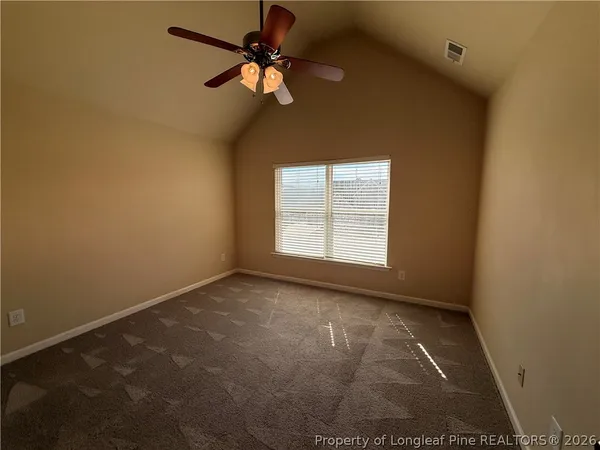 an empty room with a window and a ceiling fan