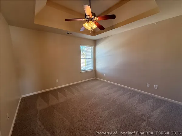 a view of an empty room and window and a ceiling fan