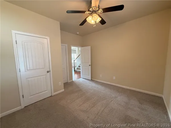 an empty room with chandelier fan