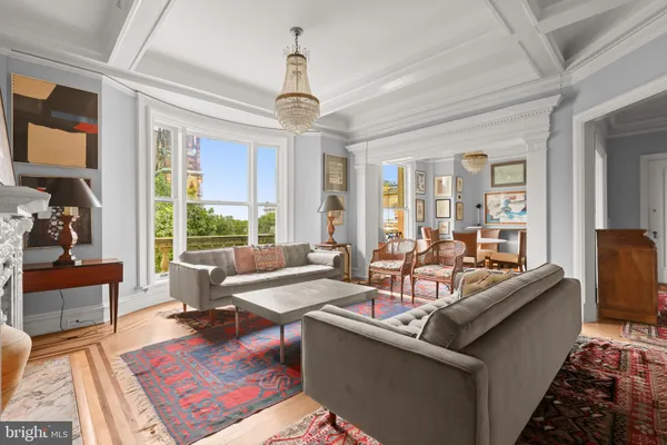 a living room with furniture a fireplace and a large window