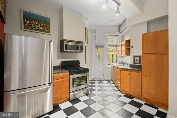 a kitchen with stainless steel appliances granite countertop a refrigerator and a stove top oven