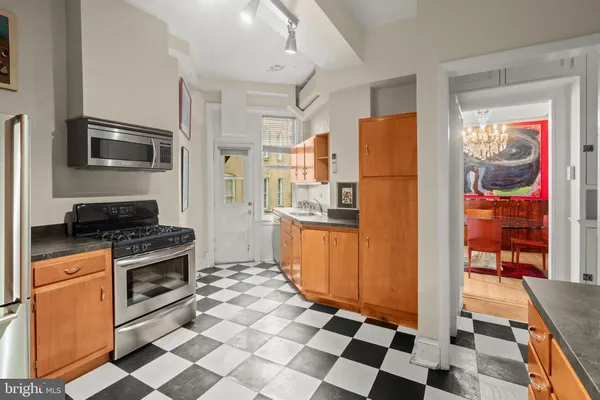 a kitchen with granite countertop a sink cabinets and stainless steel appliances