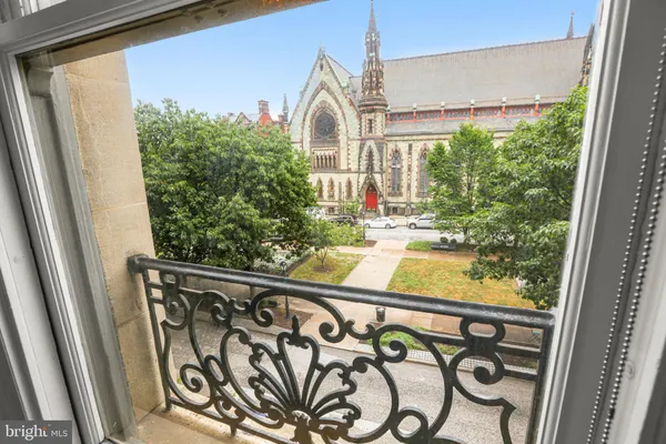a view of a building with a yard and large trees