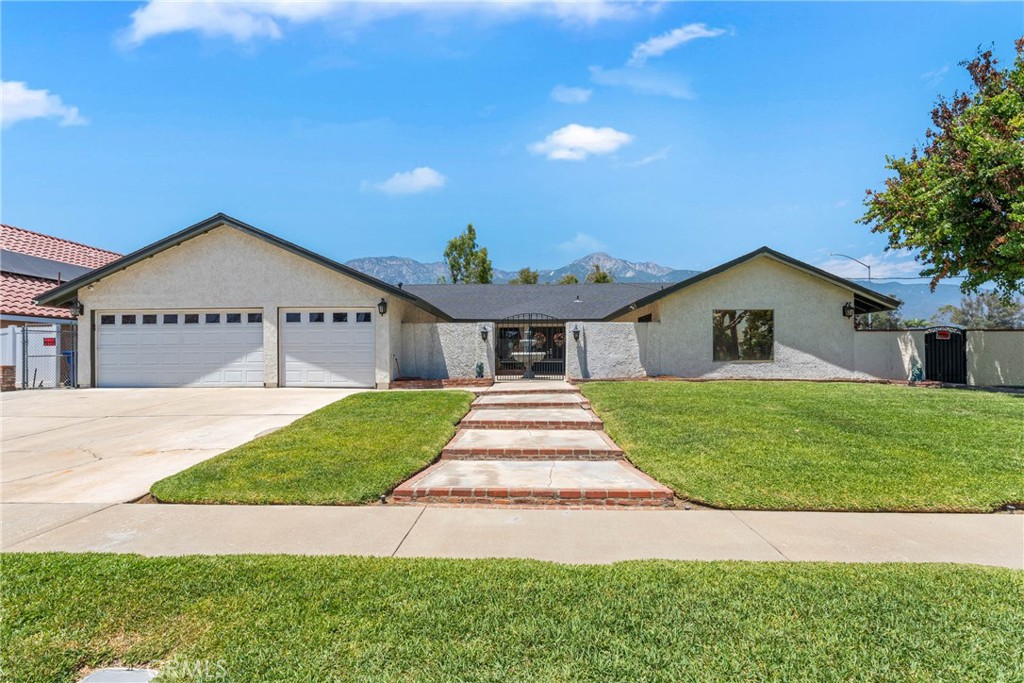 9292 Garden Street Rancho Cucamonga, CA 91701 - Photo 1 of 1 a front view of a house with a yard and garage