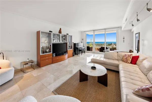 a living room with furniture kitchen view and a flat screen tv
