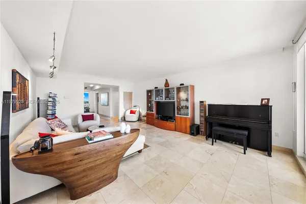a kitchen with stainless steel appliances kitchen island granite countertop a refrigerator a stove a sink dishwasher and white cabinets with wooden floor